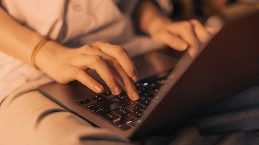 mystery writer typing on laptop